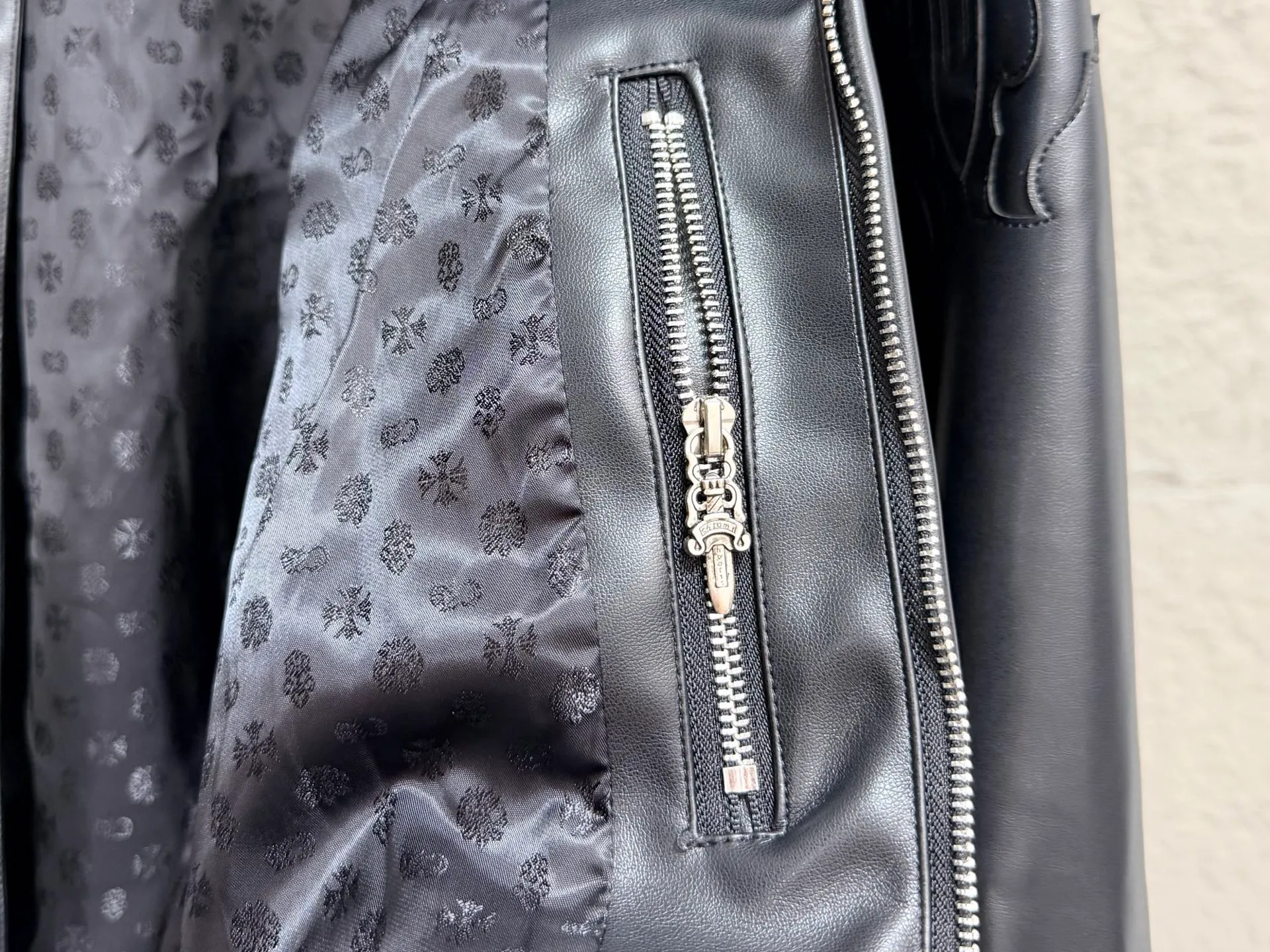 CH/Cro Heart Sword Stand Collar Leather Jacket ●"Original purchase and development, 1:1Quality" ●Arm sword embroidery, large dark pattern floral base + sword metal accessories, complex embroidery positions, strict stitch density control, and three-dimensional outline without blurring ●The sword hardware is independently molded, and the carving details and old metal texture are all restored in place. The stand-up collar has precise curvature. The main placket zipper, collar flower-shaped snap buttons, and cuff zippers are all customized hardware, and the detailed textures are aligned one by one. ●The split stitching in the middle of the back is neat, the metal nameplate at the bottom of the hem is independently molded, and the installation points are strictly based on the original version. ●Size: S M L XL